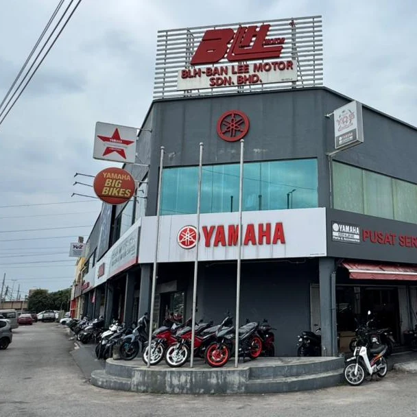 BLH Motor head office at Jalan Balkis 3/2, Malim — a grey two-storey building with a BLH-BAN LEE MOTOR SDN. BHD. rooftop sign, large red YAMAHA and PUSAT SERVIS signage, a Yamaha Big Bikes sign, and motorcycles lined up along the forecourt.
